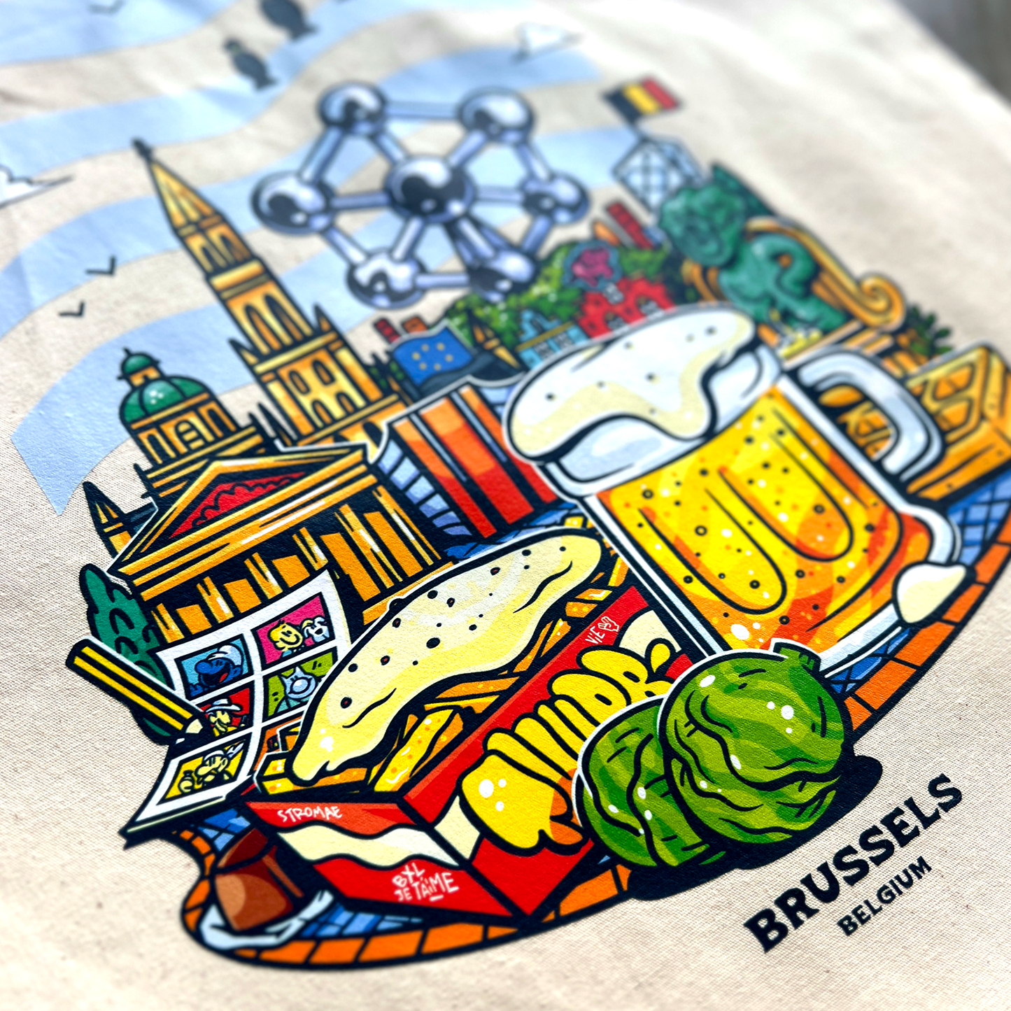 Tote bag avec une image de la ville de Bruxelles avec pleins d'éléments représentants la ville comme des boissons, des plats et des monuments.