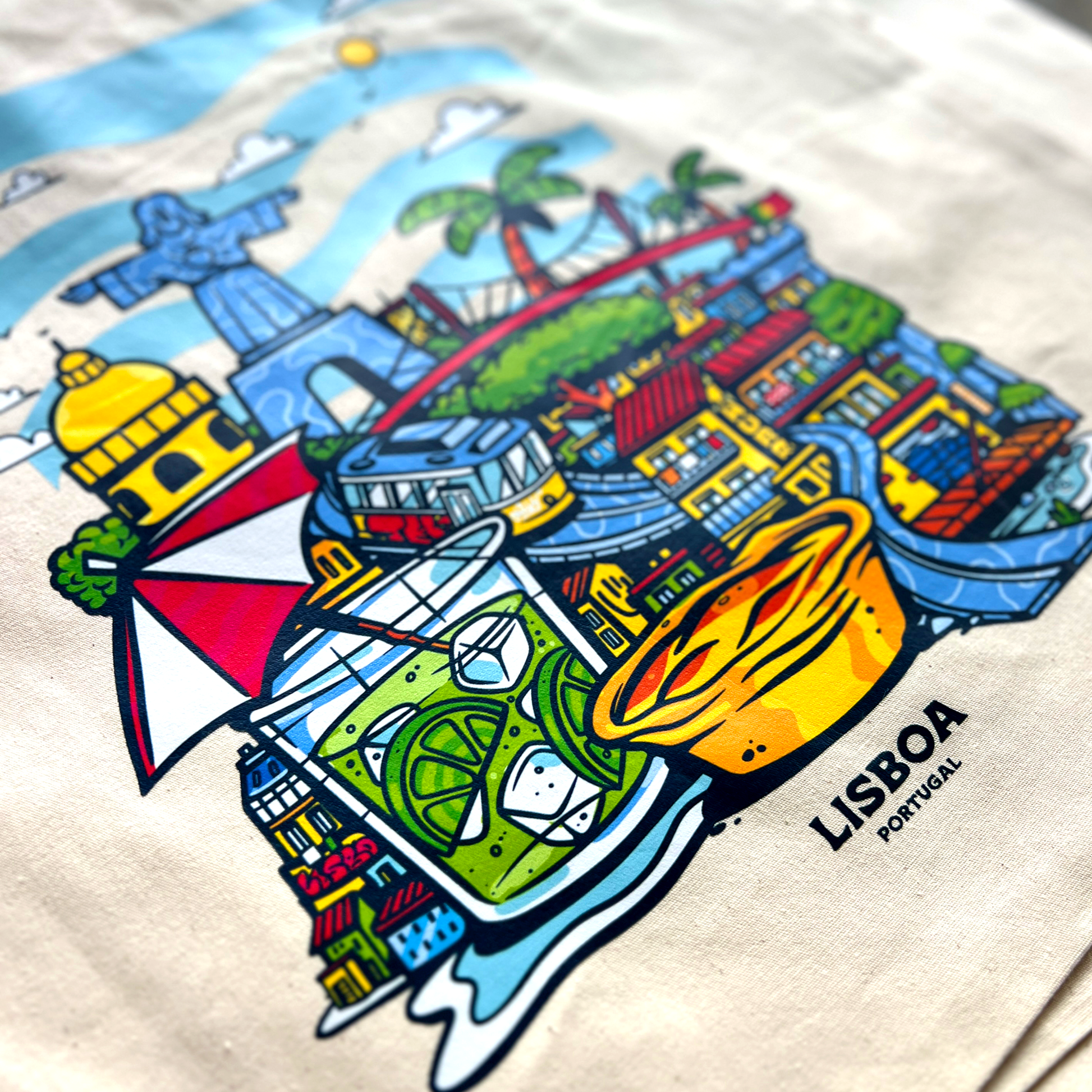 Tote bag avec une image de la ville de Lisbonne avec pleins d'éléments représentants la ville comme des boissons, des plats et des monuments.